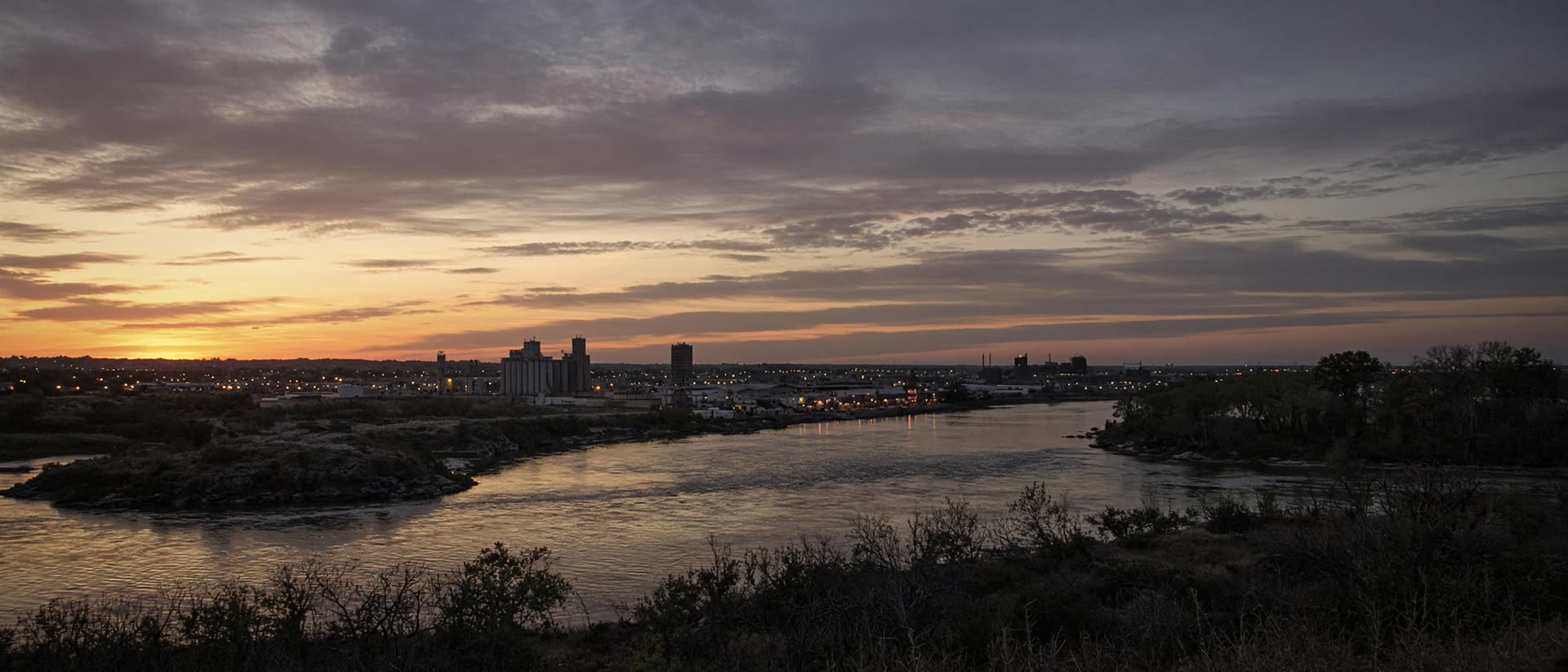 Dusk over Sioux Falls prairie and industrial silhouettes